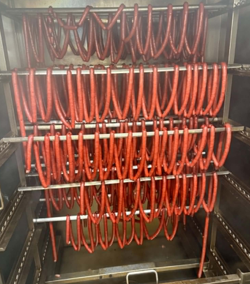 Sausages curing on rack in our smokehouse